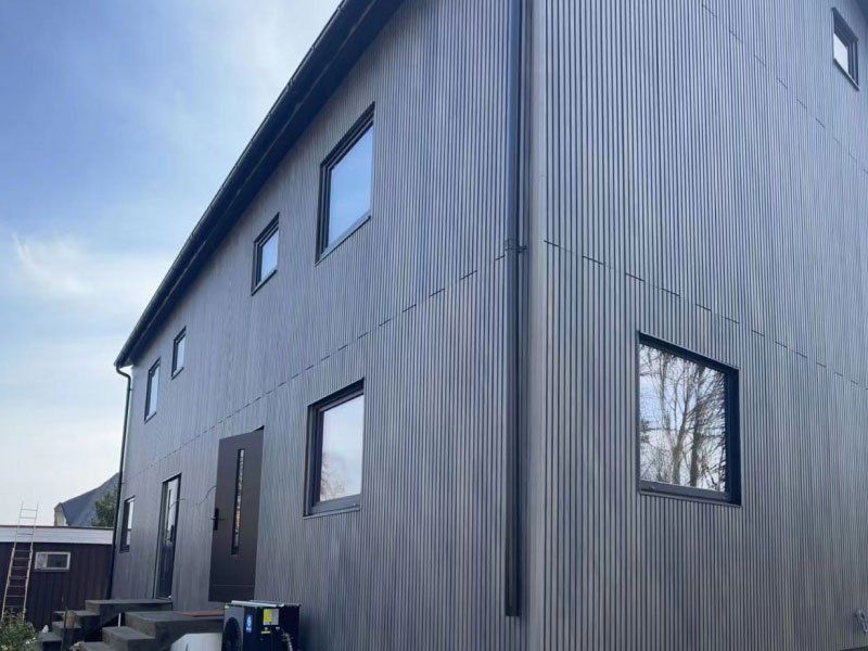 Maison habillée de lames gris anthracite, pose verticale